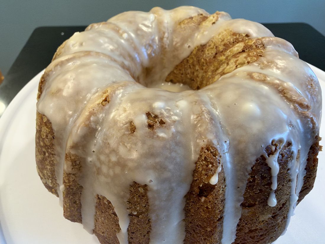 A glazed bundt cake on a white plate